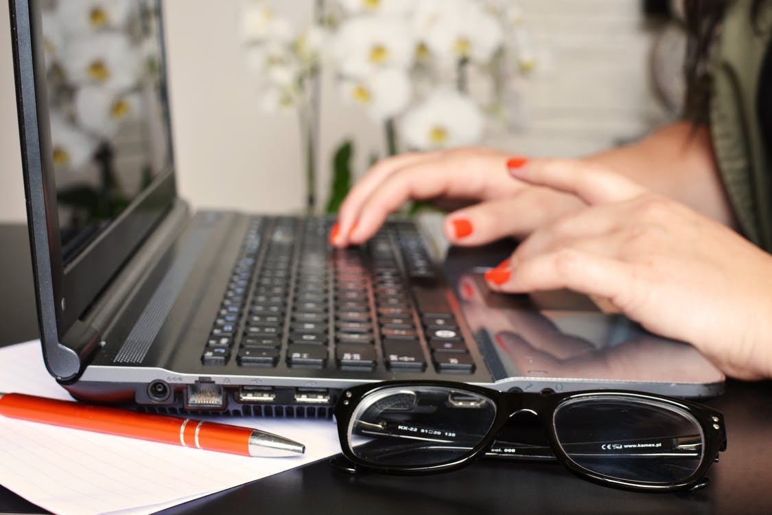 Close up of a woman typing on a laptop