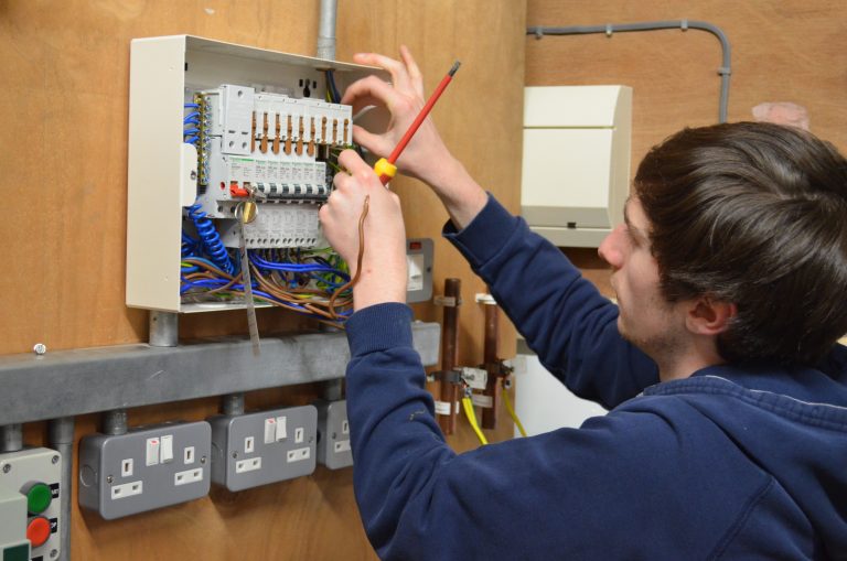 Electrical student working at a fuse board.