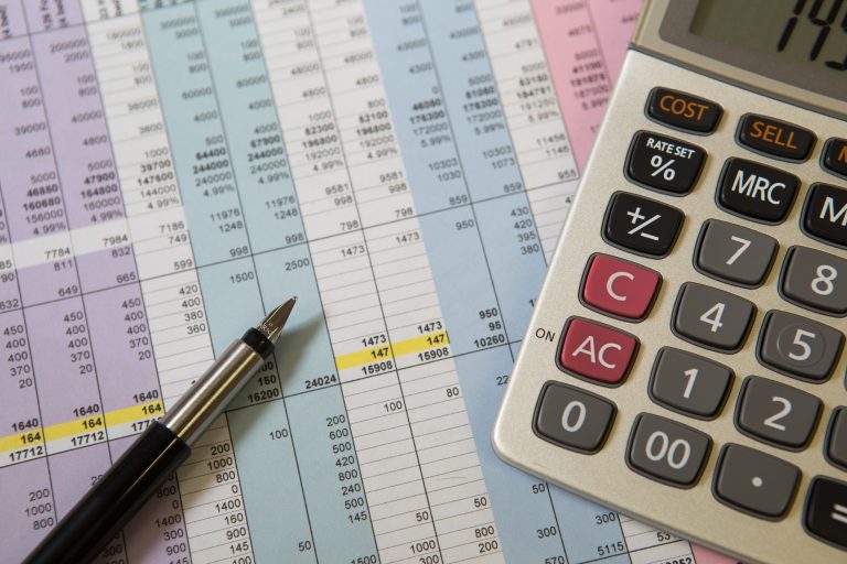 Calculator and pen on a table.