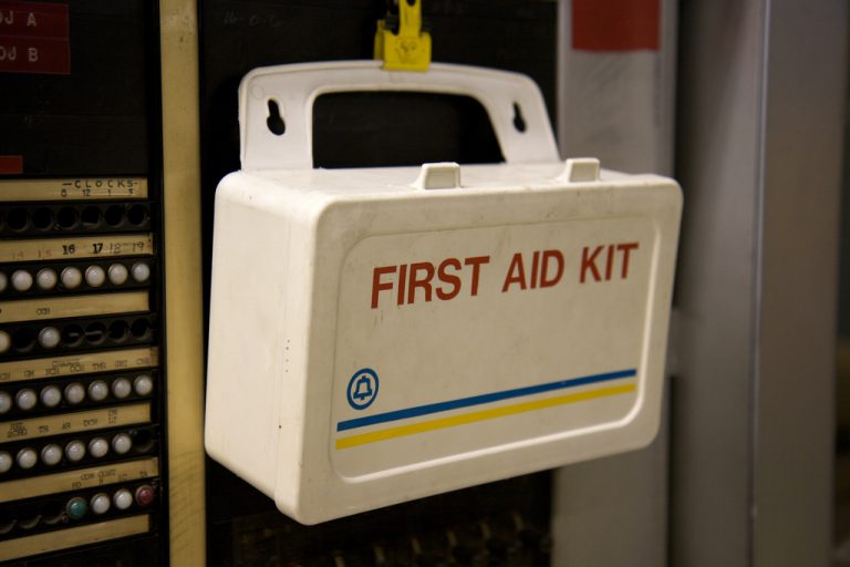 First aid box hanging up on a wall.