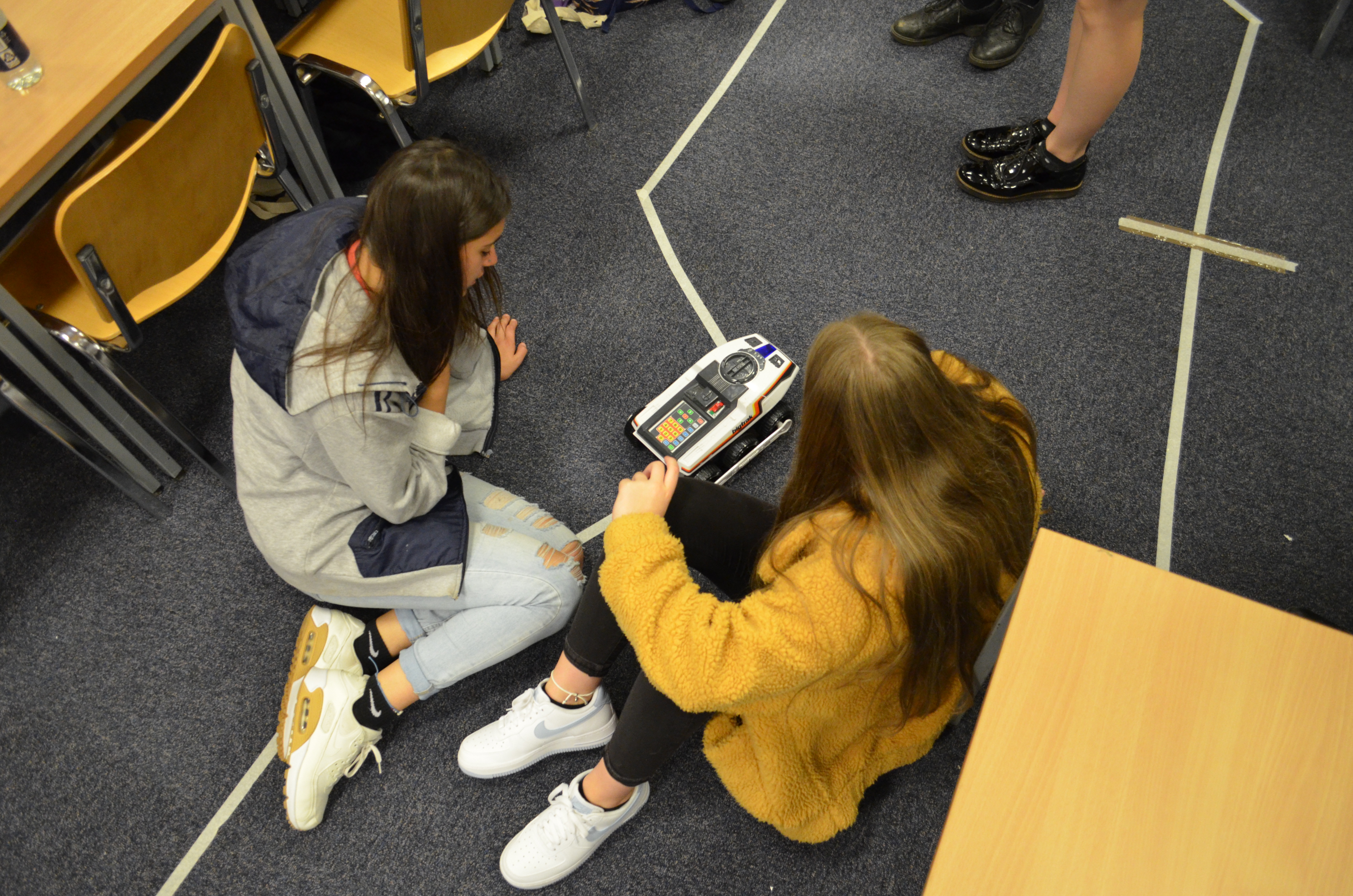 Two students programming a robot to follow a path at Women in Engineering Day.