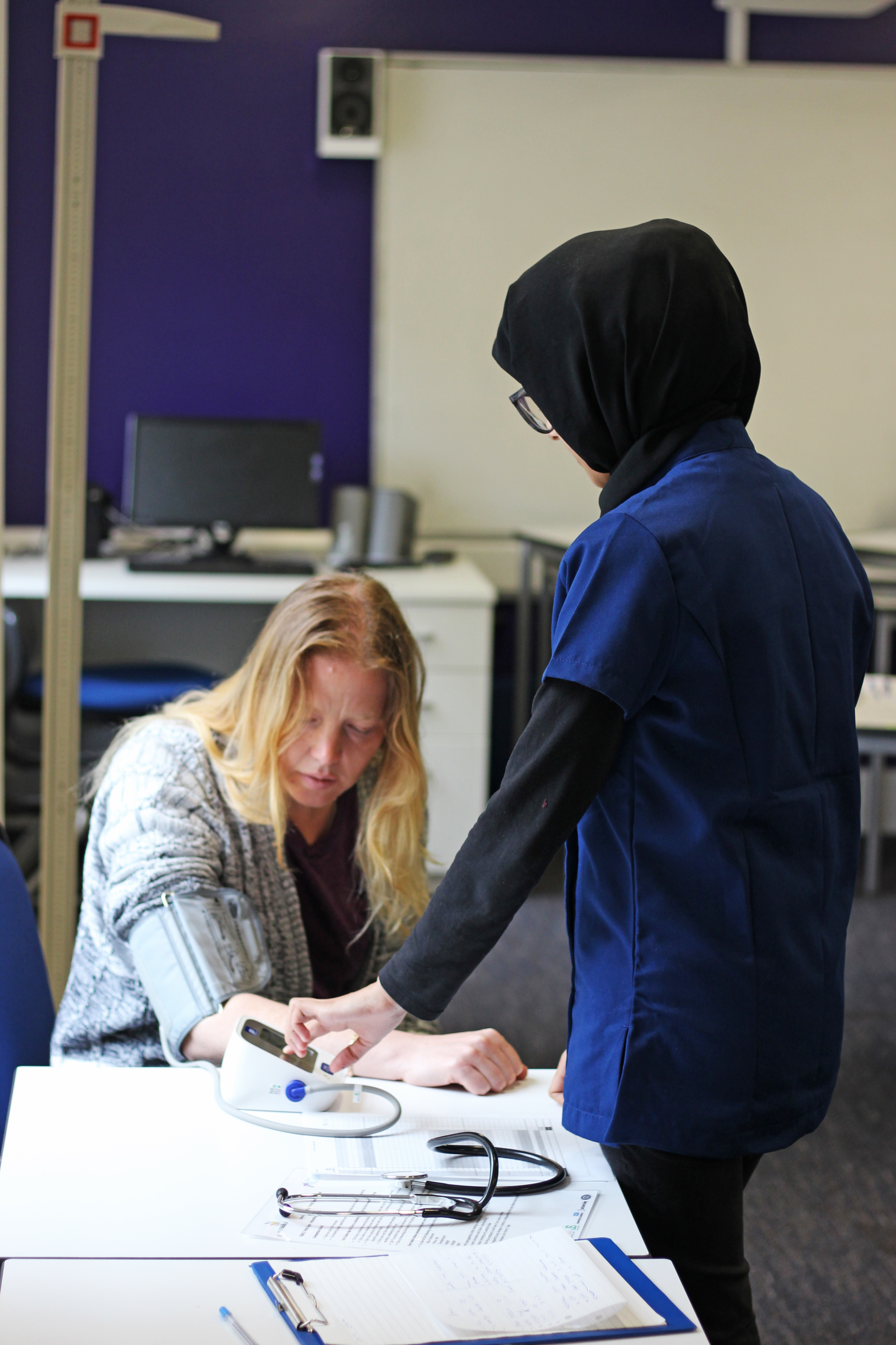 Student taking a patient's blood pressure during WorldSkills UK health and social care competition.