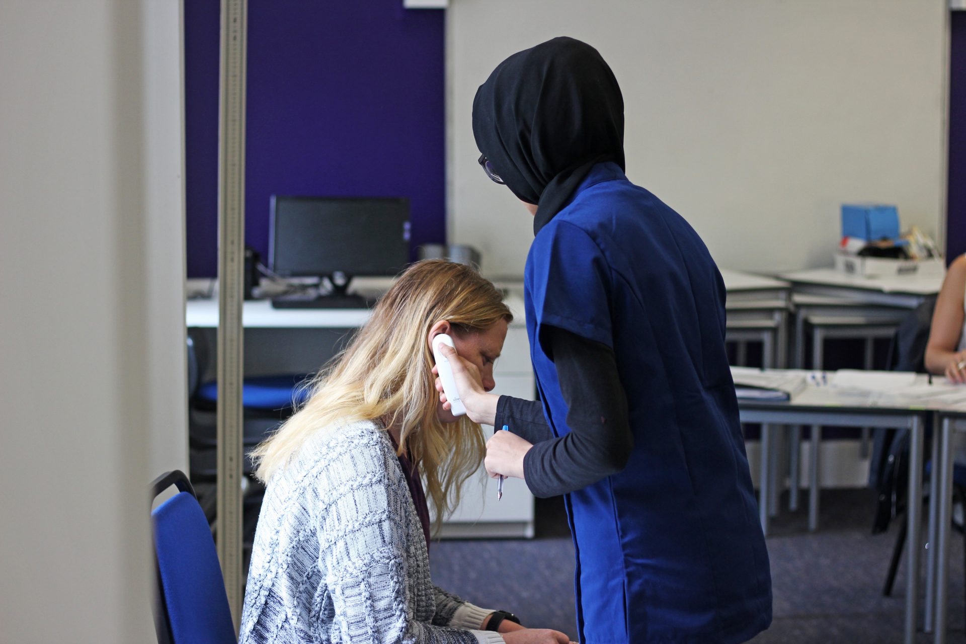 Student taking a patient's temperatue during WorldSkills UK health and social care competition.