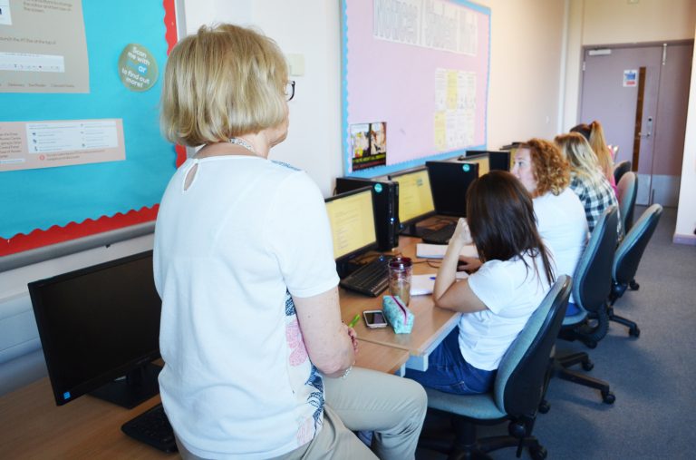 Teacher talking to students on computers