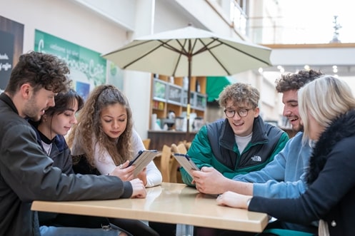 6 students on iPads around a table