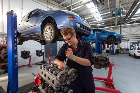 Automotive student working on a car engine
