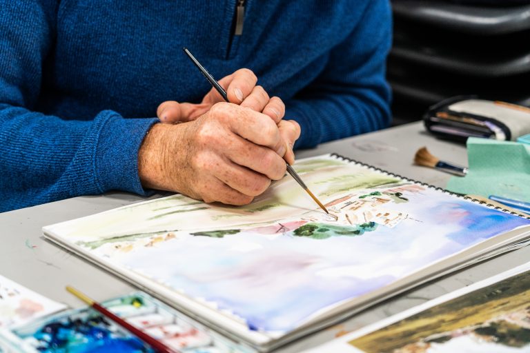 Man painting an image of landscape