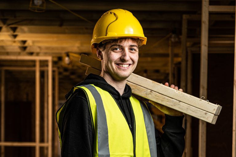 construction student holding a plank of wood