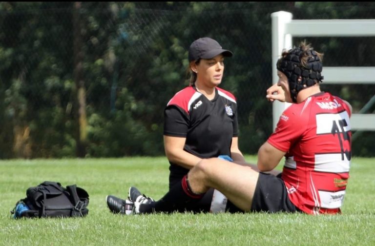 Kerry Mitchell making sure rugby player is not injured