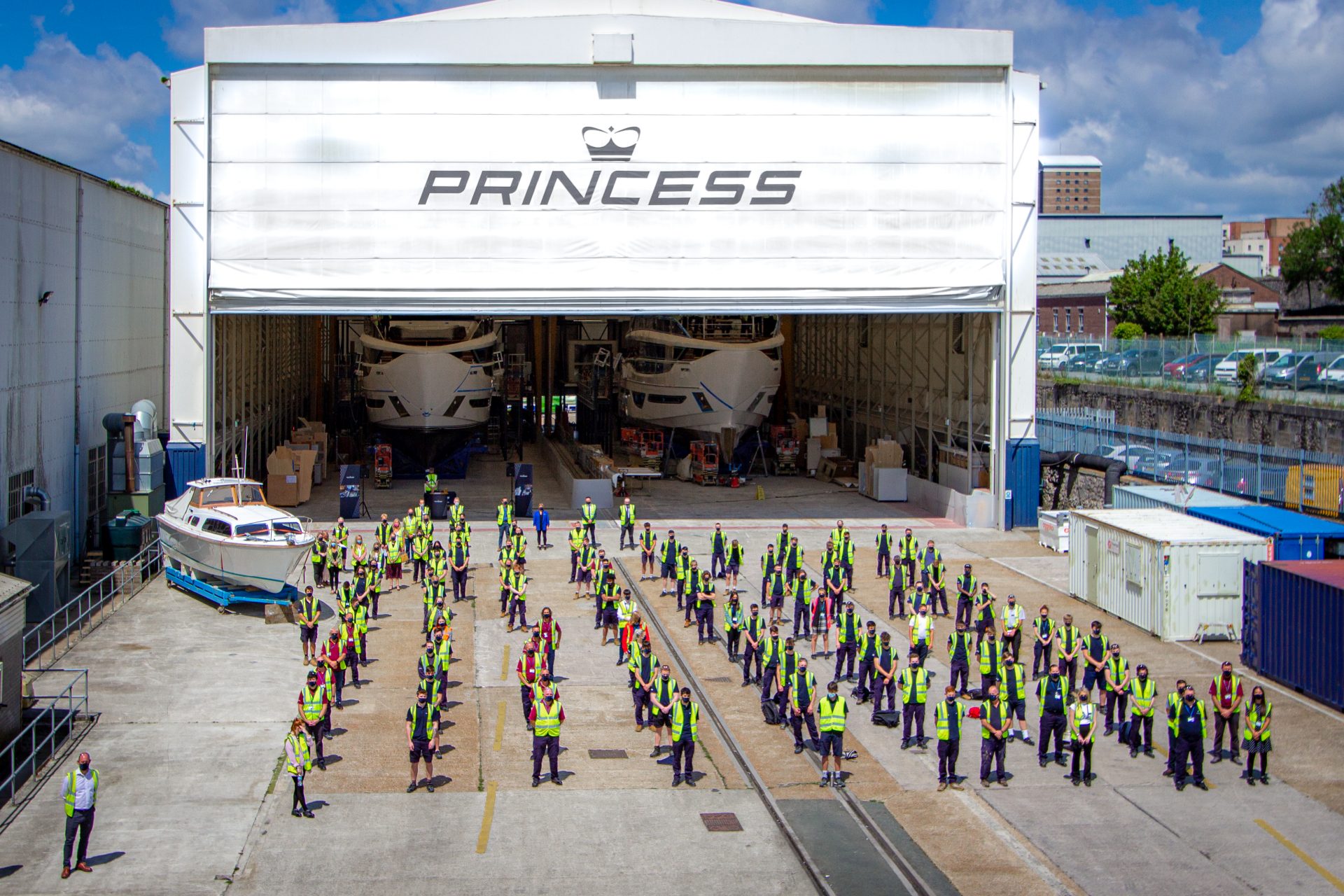 Princess Yachts employees standing in front of super yachts