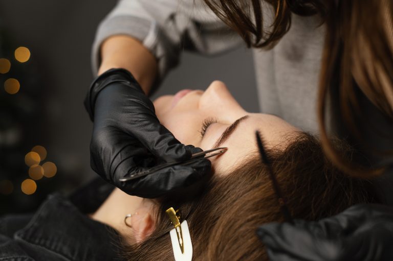 female specialist doing eyebrow treatment woman