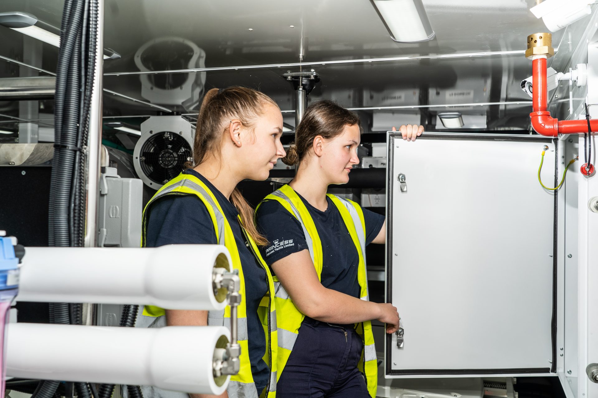 Two Princess Yachts apprentices working in boat engine room