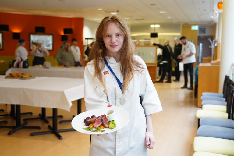 Chef student holding a plate of food
