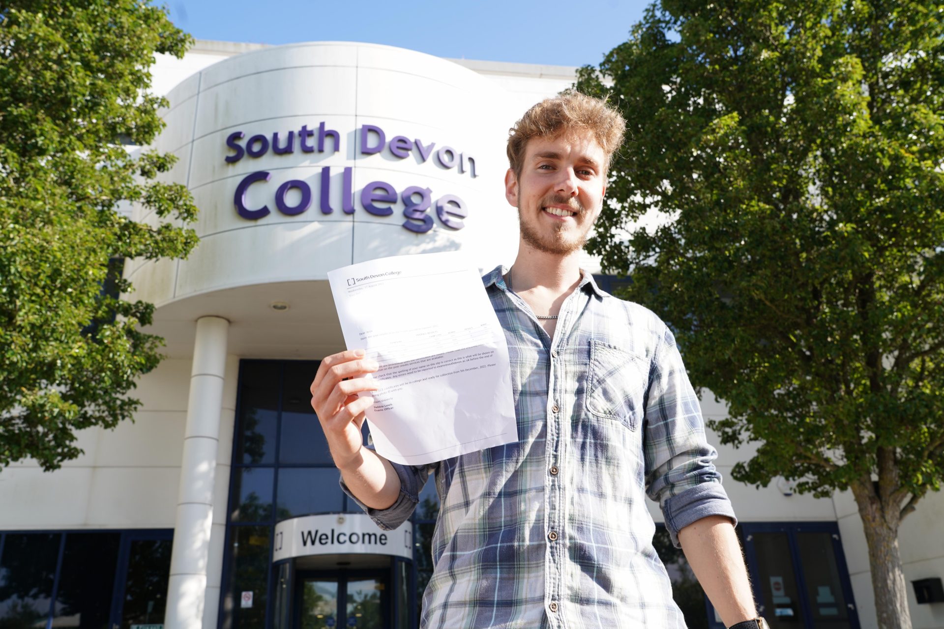Aron Briggs celebrating on results day outside South Devon College