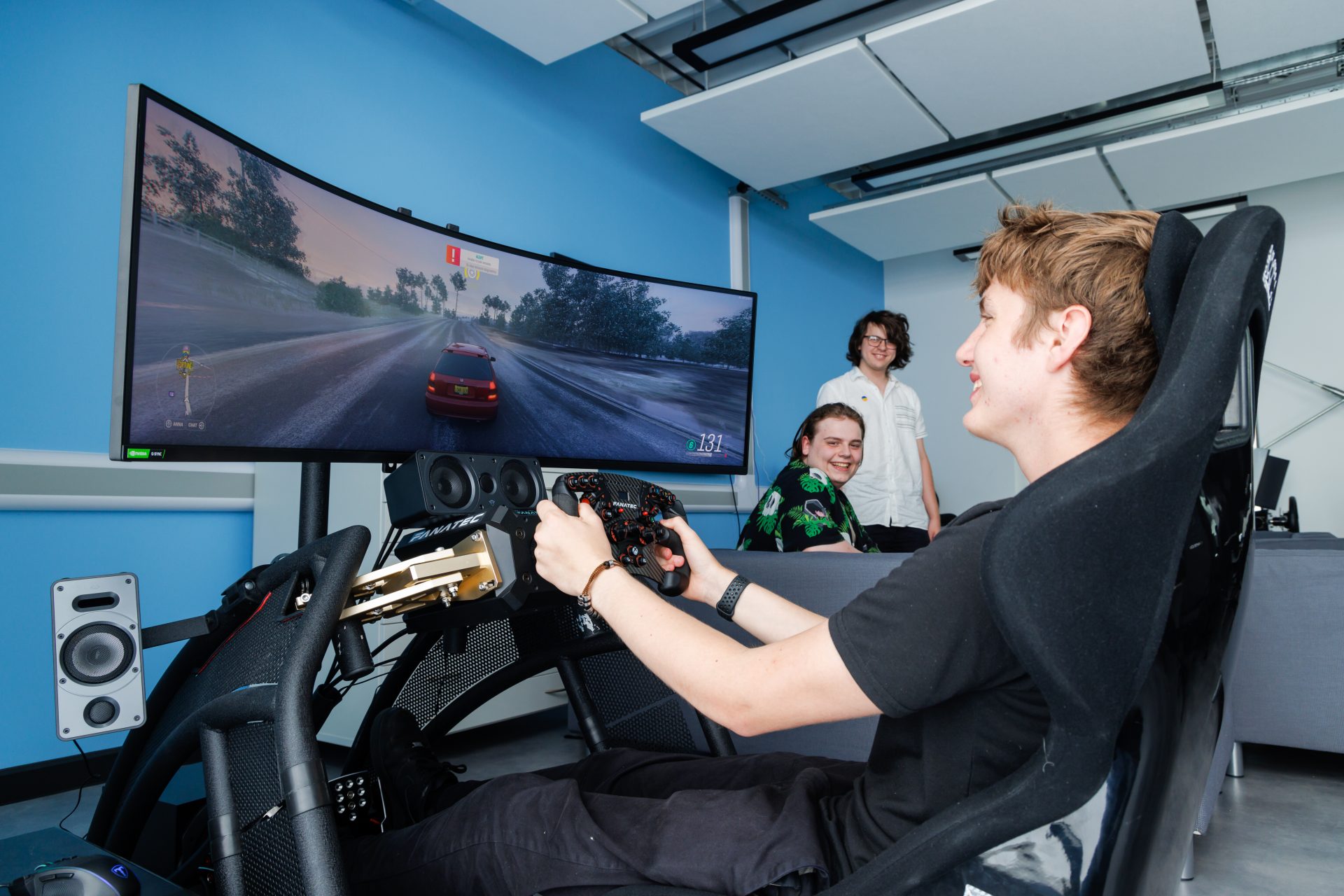 Students playing game in driving simulator